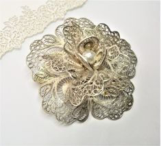 Featuring superior craftsmanship and a timeless design, this silver filigree brooch is sure to make a lasting impression. Intricate floral details and three-dimensional layering mean this vintage piece is no ordinary accessory. Perfect for special occasions, this sterling silver brooch is a luxurious accent that will enhance your ensemble. Large Sterling SILVER marked FILIGREE BROOCH A Flower  sculptured  vintage, boxed Length: 2 1/4 inches, 5.5 cm A fine gift for life Victorian Wedding Brooches With Intricate Design, Antique Wedding Brooch With Intricate Design, Elegant Silver Brooches For Vintage Events, Heirloom Wedding Brooches With Intricate Design, Victorian Filigree Brooches For Vintage Events, Ornate Wedding Brooches With Intricate Design, Ornate Wedding Brooch With Intricate Design, Elegant Silver Brooch With Intricate Design, Heirloom Filigree Brooches For Anniversary