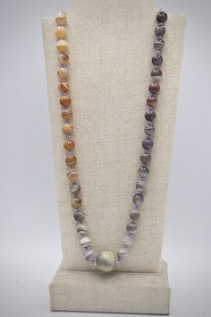 "This handmade organic necklace is made of round glossy 8mm agate beads. Agate comes in a variety of colors naturally and a range of grey purples to warm peach tones are showcased in this gradient piece. The stripes on these stones are a cool white and resemble planetary bodies. The overall golden tones of the agate beads are complimented with a gold-filled chain and spacer beads around the central 12mm round stone. The beads are knotted between the chain on lavender-colored silk. This piece arr Gray Bohemian Necklace With Round Beads, Bohemian Gray Round Bead Necklace, Single Strand Agate Round Necklace, Adjustable Gray Necklace With Gemstone Beads, Adjustable Gray Gemstone Beads Necklace, Single Strand Round Agate Necklace, Adjustable Gray Gemstone Beaded Necklace, Gray Gemstone Beads Necklaces For Gifts, Gray Gemstone Beads Necklace For Gift