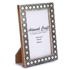 a wooden frame with black and white designs on the front, sitting in front of a white background