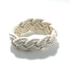 Imagine your visit to the beaches of New England.  This is the bracelet you see everywhere.  This bracelet is made from the classic cotton cord custom made to reflect the traditional rope used on our classic yachts.   Historically, these were given by sailors to their loves when they went on long voyages.  in the 1920's, the Newport Yachting Clubs were making these as a reward for a great season serving on their racing sailboats.  This traditional white cotton bracelet is 1 inch wide and comes in 3 sizes. Please let us know if you need a size not listed.  Stretch on over your hand, then get wet to shrink onto your wrist! Small - fits children and very fine framed women with a wrist size of 5 - 6 inches, inside circumference of 6 inches. Medium - fits women and teenagers with a wrist size o White Braided Jewelry For The Beach, White Braided Jewelry For Beach, Handmade Nautical Style Bracelets For Beach, Handmade Nautical Bracelets For Beach, Racing Sailboats, Sailor Knot Bracelet, Sailor Bracelet, Sailor Knot, Mystic Ct