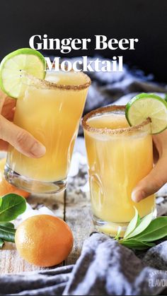 two people are holding glasses with orange juice and limes on the table next to them