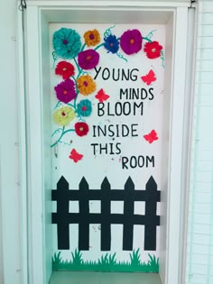 a door decorated with flowers and the words young minds bloom inside this room