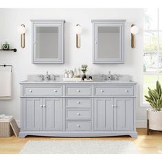 a bathroom with two sinks and mirrors on the wall next to a rug in front of it