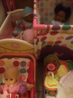 two baby dolls are sitting in their cribs