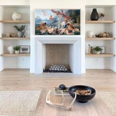 a living room filled with furniture and a fire place in front of a painting on the wall