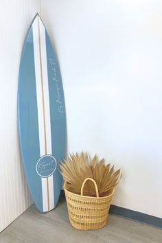 a blue surfboard next to a wicker basket