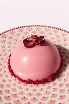 a pink dessert sitting on top of a plate