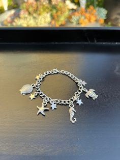 Cool charm bracelet that is lightweight and fun to wear with almost anything! Beach Jewelry With Metal Charms, Beach Jewelry With Dangling Metal Charms, Metal Charm Bracelets For Beach, Vacation Bracelet With Starfish Charm, Beach Metal Bracelets With Charms, Beach Jewelry With Lobster Clasp, Beach Metal Jewelry With Starfish Charm, Adjustable Chain Bracelet For Beach, Beach Charms Bracelet Jewelry