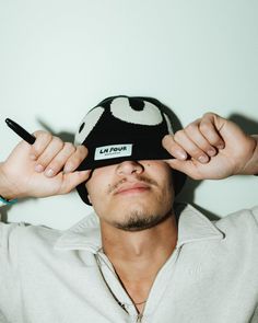 a man is holding his hat over his eyes