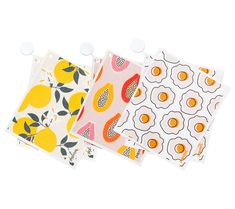 three placemats with fruit designs on them are lined up against a white background