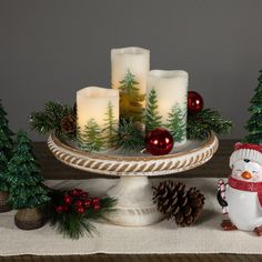 candles are sitting on a platter with christmas decorations