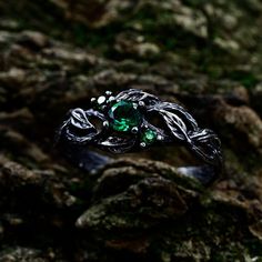 This oxidized silver engagement ring has a design that was inspired by nature and is made up of entwined branches and leaves. A splash of vivid green is added to the design by three exquisite emeralds that are tucked between the leaves. This ring is the perfect option for a fan of nature or someone who values good craftsmanship because the complex branches and green gemstones symbolize the beauty and tenacity of the natural world.  Characteristics: Metal - Recycled solid sterling silver  Stone - Cubic Zirconia Finish - Oxidized. View all silver branch rings: https://www.etsy.com/shop/TinyShinyJewel?ref=seller-platform-mcnav&section_id=43346778 Care instructions: To care for the ring, avoid contact with water and chemicals such as perfumes and lotions. When the ring is not in use, store it Mystical Crystal Promise Ring, Silver Emerald Birthstone Ring With Accent Stones, Emerald Stone Setting Promise Ring, Spiritual Crystal Ring With Stone Setting For Promise, Mystical Style Silver Promise Ring, Silver Fantasy Promise Ring, Mystical Silver Promise Ring, Sterling Silver Fantasy Style Promise Ring, Magical Gemstone Crystal Promise Ring