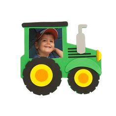 a green toy tractor with a little boy in it