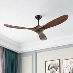 a ceiling fan mounted to the ceiling in a room with two pictures on the wall