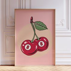 two cherries with green leaves on them are hanging in front of a pink wall