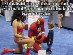 a woman sitting on the ground next to a little boy wearing a red and yellow costume