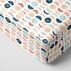 an image of a baby crib sheet that has circles on it and is in pastel colors