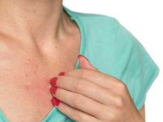 a woman with red nails holding her chest