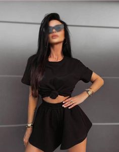 Unveil your style with this sophisticated black outfit. Featuring a chic knotted crop top and ultra-comfortable high-waisted shorts, this ensemble effortlessly combines fashion and comfort. Ideal for every casual outing or laid-back gathering, this versatile set will elevate your wardrobe. Available in various sizes to fit every body type, this must-have outfit ensures you step out in confidence and charm. Casual Solid Color Mini Shorts, Casual Mini Length Solid Color Shorts, Solid Color Summer Sets For Night Out, Summer Solid Color Sets For Night Out, Solid Color Sets For Night Out In Summer, Chic Crop Top For Loungewear, Casual Black Short Set For Summer, Casual Black Short Set, Black Short Sleeve Crop Top For Loungewear