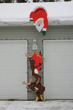 two christmas decorations hanging from the side of a garage