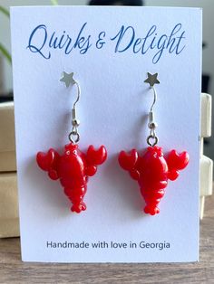 Hey ocean lovers! Add a touch of coastal charm to your look with these playful lobster earrings. Handmade with love using hypoallergenic hardware, these vibrant red resin earrings feature adorable lobster-shaped charms for a fun, whimsical accent. They're perfect for adding a quirky flair to your everyday outfit or a themed summer party. Plus, they are nickel-free and lightweight, making them ideal for those with sensitive ears. Whether you're a seafood lover or just enjoy unique accessories, th Lobster Earrings, Coastal Jewelry, Tiny Charm, Red Lobster, Unique Accessories, Fun Cute, Ocean Inspiration, Cute Gift, Accessories Unique