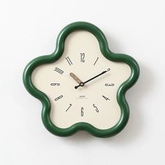 a green and white clock with numbers on the face is shown against a white background