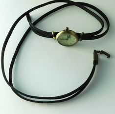 This is a wristwatch, wrap around style. The face of the watch is round, 1.25 inches diameter, greenish quadrant with numerals and three hands. The band is made with two straps of distressed black and brown leather and will be round three times around your wrist. The band will be custom size, please, select the measure of your wrist when you buy it. Comes in a gift box with a spare battery. Thank you, MJ Adjustable Analog Watch With Round Dial, Vintage Adjustable Watch Accessories With Analog Display, Matt Brown, Three Hands, Wrist Watches, Types Of Fashion Styles, Wrap Around, Exclusive Designs, Retro Style