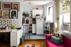 a living room filled with furniture and lots of pictures on the wall next to a kitchen