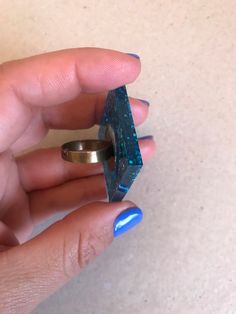 This is an adjustable ring made with epoxi resine and blue sparkling mica. Each piece is unique, handmade fabrication. The resin itself is sealer and water proof but to increase the longevity of the ring band itself the ring should be removed before hand washing and should avoid contact with house hold cleaners. We strive for 100% customer satisfaction. If any problems are encountered upon receipt, please notify me for a quick and friendly resolution. Don't forget to make sure your Etsy address Unique Blue Resin Rings, Blue Resin Rings For Gifts, Blue Resin Rings Perfect As Gifts, Blue Resin Rings Perfect For Gifts, Handmade Blue Resin Rings, Blue Geometric Jewelry As A Gift, Blue Geometric Jewelry For Gifts, Handmade Rectangular Blue Ring, Handmade Blue Rectangular Rings