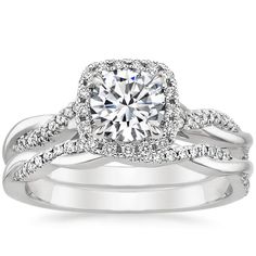 a white gold engagement ring set with a round diamond center surrounded by two rows of diamonds