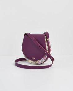 Discover timeless beauty with our Floral Engravings Plum Saddle Bag. Featuring botanical prints on the main body and crafted from recycled faux leather, this chic saddle bag is perfect for everyday essentials. The adjustable strap and luxe gold-tone hardware make it ideal for a day at the museum or a stroll through art fairs.

Key features:
  Outer: 100% Polyurethane; Lining: 100% Polyester
 
 Approx. 17 (L) x 18 (H) x 5 (D) cm
 
 Wipe clean with a damp cloth Luxury Christmas Gifts, Art Fairs, Bottega Veneta Shoulder Bag, Saddle Bag, Timeless Treasures, Everyday Essentials, Elegant Earrings, Weekender Bag, Botanical Prints