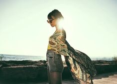 a woman standing on top of a beach next to the ocean