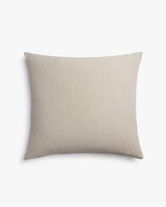 the linen pillow is made from light grey fabric and has a white border on it