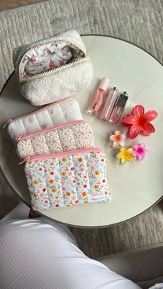 a table topped with lots of different items on top of a white plate and pink flowers