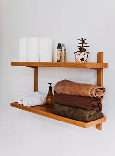 two shelves with towels and bottles on them