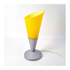 a yellow and grey lamp on a white surface with a cord in front of it