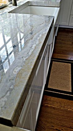 a marble counter top in a kitchen with wooden floors