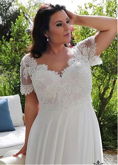 a woman in a white dress is posing for the camera with her hand on her head