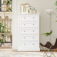 a white dresser sitting next to a plant in a living room