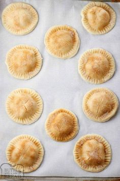 eight small pies on a baking sheet ready to go into the oven for dinner