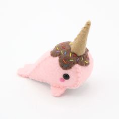 a pink stuffed animal with an ice cream cone on it's head and sprinkles