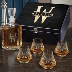 four whiskey glasses sitting on top of a wooden table