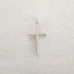 One of several different cross options. This is our thinner and smaller cross and can be worn independently or combined with our charm necklaces. A great way to keep your faith close to you! Available in Gold Fill or Sterling Silver Dimensions: 1 1/4" long and 2/3" wide Personalized White Cross Necklace, Simple Everyday Cross Jewelry, Sterling Silver Charm Necklace With Cross Pendant, Cross Necklace With Charms As Gift, Everyday Cross Pendant Charm Necklace, Classic Sterling Silver Cross Charm, Personalized Cross Jewelry For Everyday Wear, Personalized Everyday Cross Jewelry, White Cross Necklace For First Communion