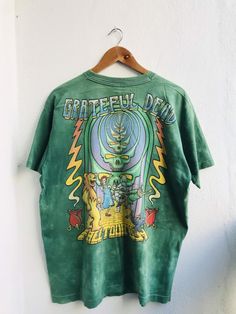 Vintage Grateful Dead Follow The Golden Road Fall Tour 1994 Rock Band T-Shirt. One multipurpose item of clothing for the upper body is a shirt. It is an essential article of apparel since it is available in an enormous array of hues, patterns, and materials. In addition to characteristics like sleeves, a collar, and buttons on the front, shirts are available in an array of designs and styles to accommodate a wide range of preferences and situations. Not only is wearing a shirt a fantastic option Psych Rock, Band Shirt, Grateful Dead, Rock Band, Stylish Shirts, Upper Body, Rock Bands, Fashion Games, Ladies Tops Fashion