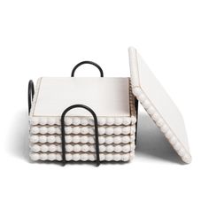 a white basket with black handles on it