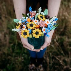 a person holding a vase with flowers in it