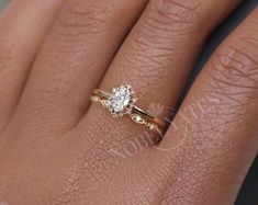 a woman's hand with a diamond ring on top of her finger and an engagement band