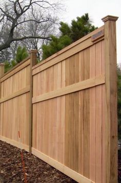 a wooden fence that is next to a tree