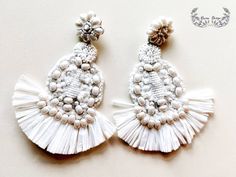 two pairs of white beaded and tasselled earrings