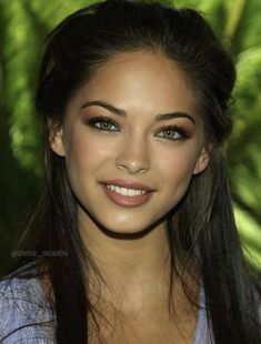 a beautiful young woman with long hair smiling at the camera